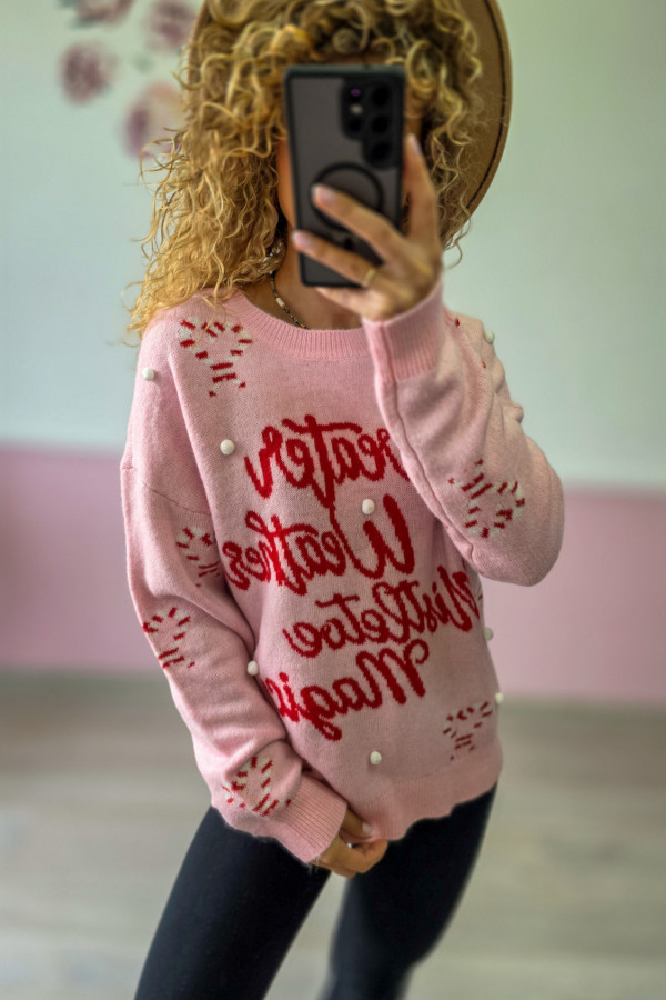 Różowy sweter świąteczny z czerwonymi napisami